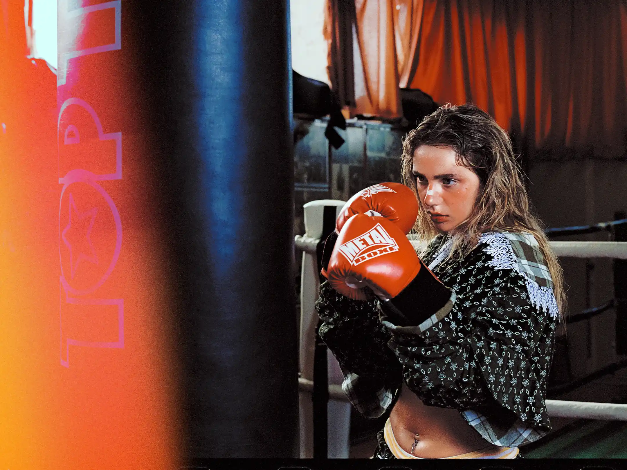 Romane Parc holding her guard behind a heavy bag, red glove raised to the jaw
