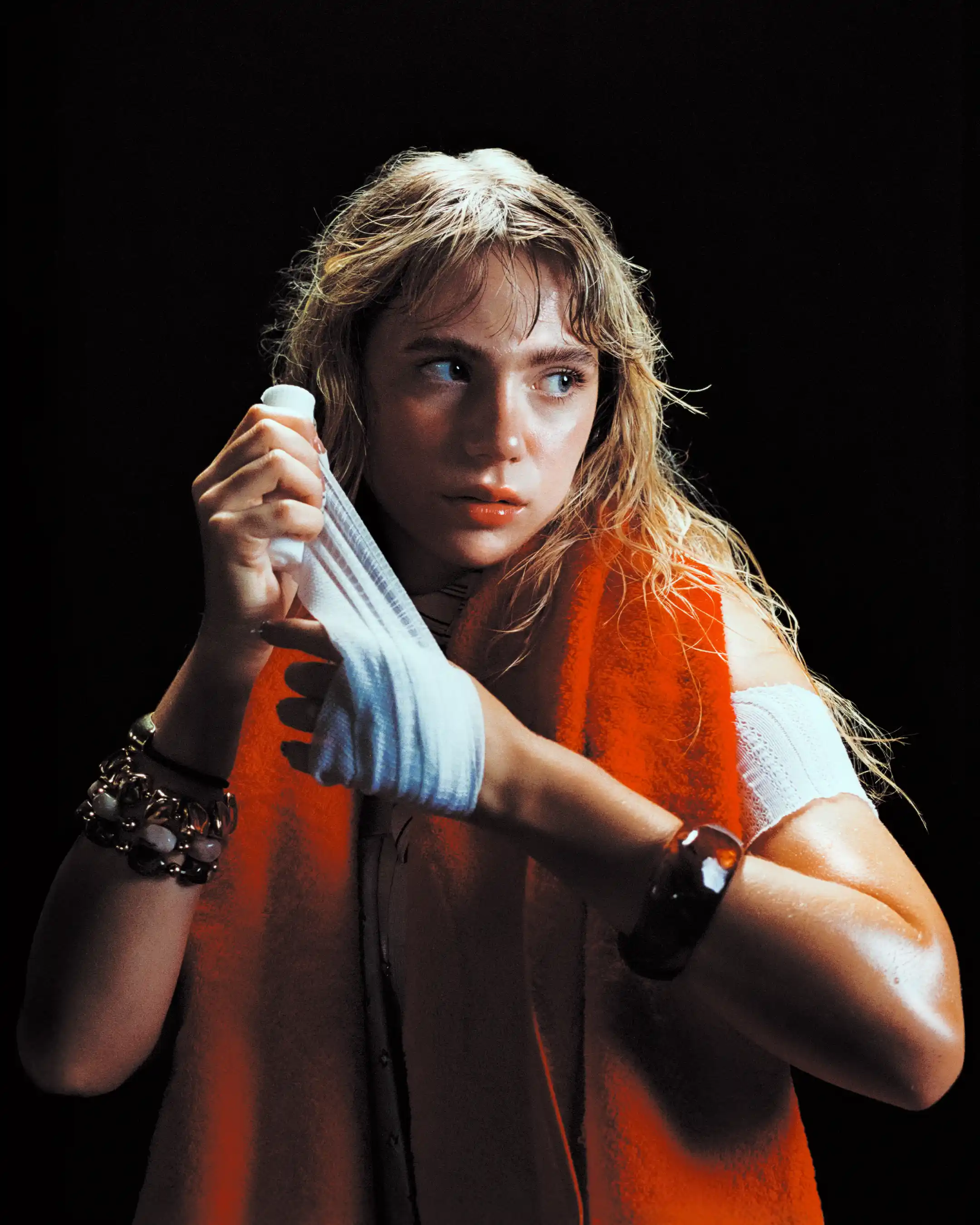 Romane Parc wrapping her hands against a black background, orange towel over her shoulders