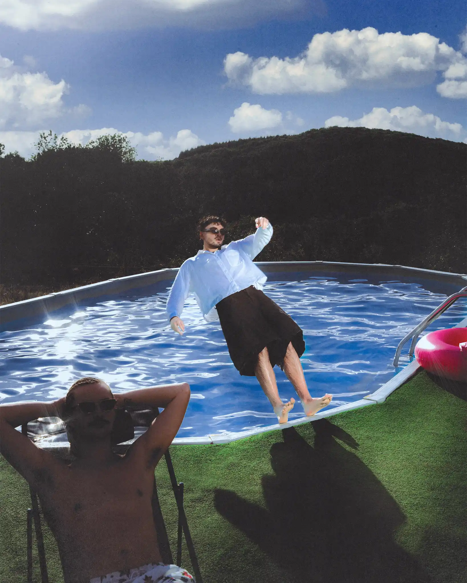 Tyron B. caught mid-fall backwards into the pool while a sunbather stays put in the foreground