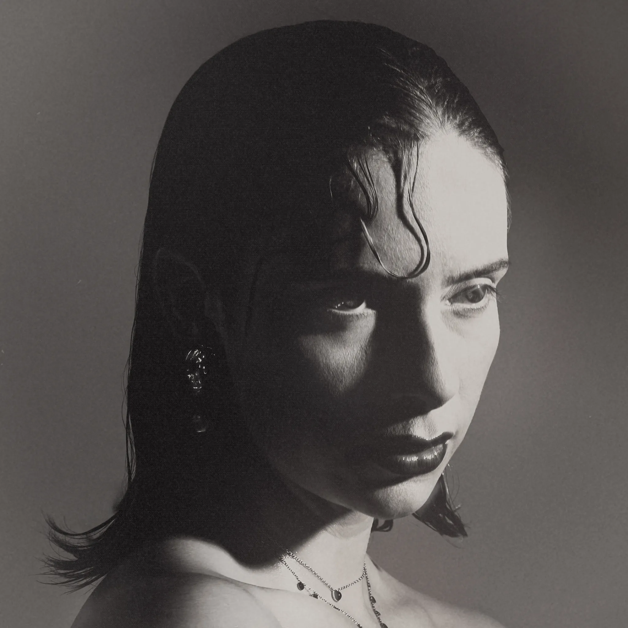 Black and white studio portrait of Marine D., chin lowered and stare held straight into the key light