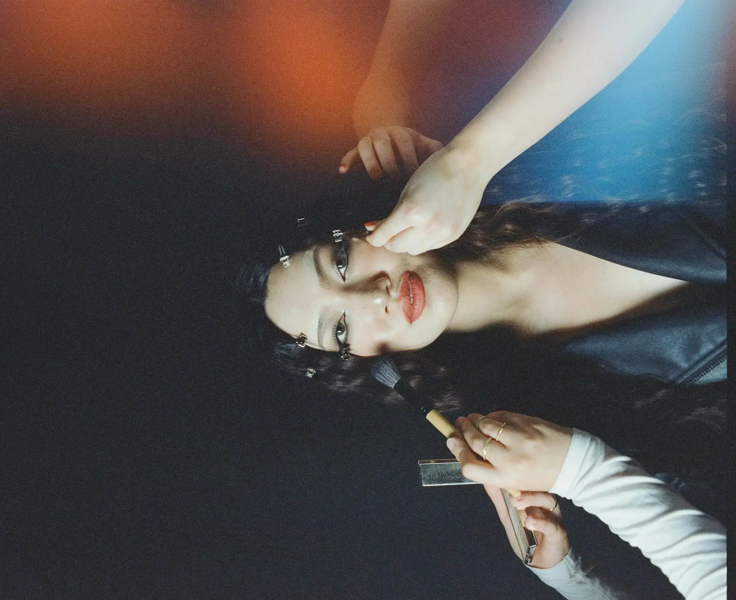 Miho S. having her hair pinned by two pairs of hands in low light